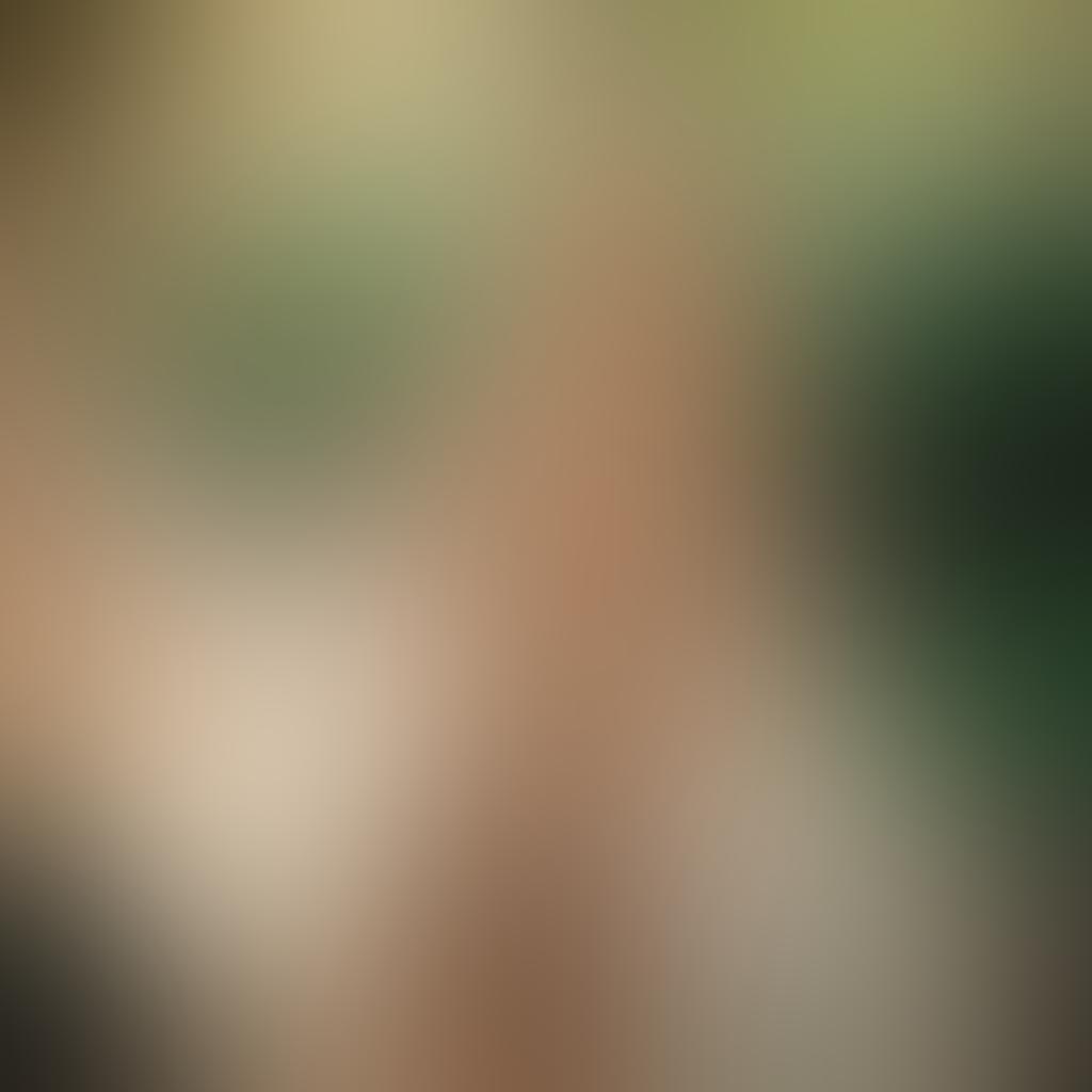 A captivating artistic nude photography scene featuring a striking blonde model in soft, natural light. The background should be a serene outdoor setting, perhaps surrounded by blooming flowers and gentle greenery. The pose should convey a sense of elegance and tranquility, with flowing fabric subtly draping around the subject. Enhance the image with warm, glowing tones to evoke a feeling of allure and beauty. super-realistic. soft focus. vibrant colors.